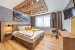 a bedroom with a bed and a desk in a room at Apart Dorhoam in Umhausen