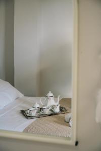 a tray with three tea sets on a bed at Γκαρσονιέρα δίπλα στη θάλασσα. in Kómi