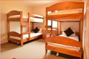a room with three bunk beds and a staircase at Sun Apartments in Mount Hotham