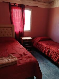 a bedroom with two beds and a window at Rincones de la Puna in Antofagasta de la Sierra
