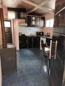 a kitchen with black cabinets and a tile floor at Rincones de la Puna in Antofagasta de la Sierra