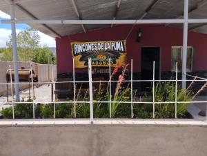 a fence in front of a building with a sign at Rincones de la Puna in Antofagasta de la Sierra