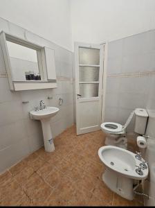 a white bathroom with a toilet and a sink at Casa céntrica en JesusMaria in Jesús María