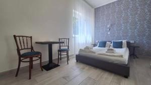 a bedroom with a bed and a table and chairs at River Apartment in Makó