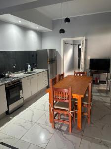 a kitchen with a wooden table and chairs in it at Hospedaje Adha Chivilcoy III in Chivilcoy
