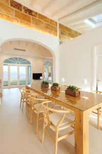 a dining room with a large wooden table and chairs at Veles Dos, villa con piscina frente al mar in Alcudia
