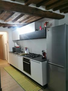 a kitchen with a stove and a refrigerator at Alloggio del Barbarossa in Acquapendente