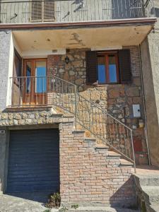 a building with a garage door and a staircase at Alloggio del Barbarossa in Acquapendente