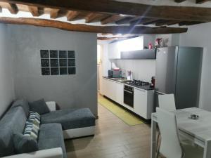 a living room with a couch and a kitchen at Alloggio del Barbarossa in Acquapendente