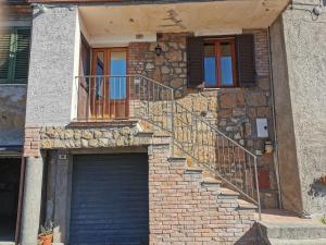 a brick house with a garage and a staircase at Alloggio del Barbarossa in Acquapendente +5 photos