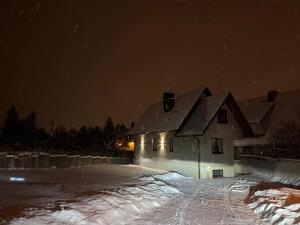 a house in the snow at night at Apartament u Bacy in Nowy Targ