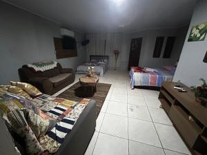 a living room with a couch and a bed at Pousada da Drika in São Gabriel