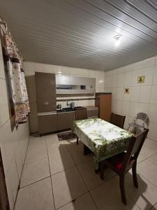 a room with a table and a kitchen with a table and chairs at Pousada da Drika in São Gabriel