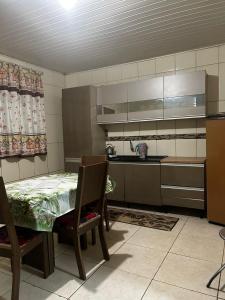 a kitchen with a table and chairs in a room at Pousada da Drika in São Gabriel