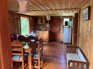 a kitchen with a table and chairs and a refrigerator at Cabañas Kalfvgen in Valdivia