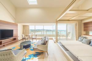 a living room with a couch and a television at Sheraton Okinawa Sunmarina Resort in Onna