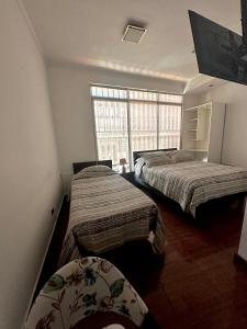 a bedroom with two beds and a window at Éclat Hotel Boutique in Iquique +6 photos