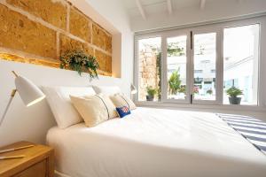 a white bed in a room with windows at Veles Dos, villa con piscina frente al mar in Alcudia +37 photos
