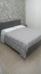 a bed in a bedroom with a brick wall at Casa Bruno in Palermo