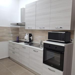 a kitchen with white cabinets and a black appliance at Casa Bruno in Palermo