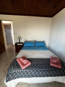 a bedroom with a bed with two towels on it at Cabañas de Mar - Calfu Huenu in Camarones
