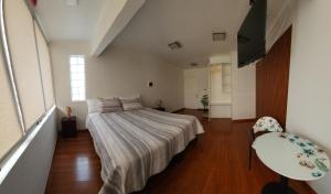a bedroom with a bed and a table and chairs at Éclat Hotel Boutique in Iquique