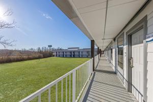 an empty balcony of a building with a grass field at HomeTowne Studios by Red Roof Athens, TN in Athens