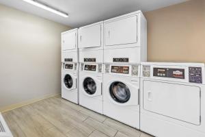 a laundry room with four washers and dryers at HomeTowne Studios by Red Roof Athens, TN in Athens