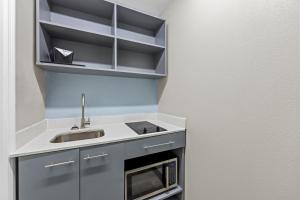 a small kitchen with a sink and a microwave at HomeTowne Studios by Red Roof Athens, TN in Athens