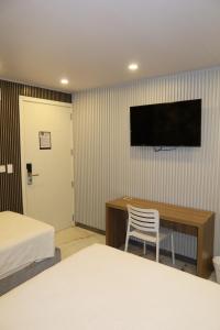 a hotel room with two beds and a television on the wall at WH HOTEL in San Andrés