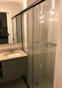 a bathroom with a glass shower with a sink at Studio Centro Curitiba in Curitiba +11 photos
