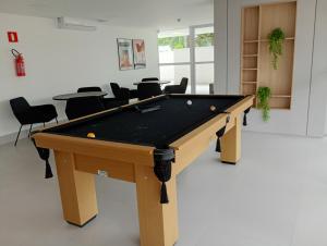 a pool table in a room with chairs at Studio Centro Curitiba in Curitiba