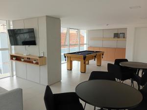 a room with a ping pong table and chairs at Studio Centro Curitiba in Curitiba
