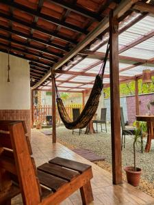 a patio with a hammock and a table and chairs at Espaço Augusto in Barreirinhas