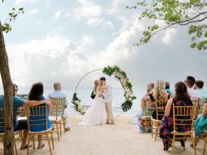 a bride and groom walking down the aisle at their wedding on the beach at Thatch Caye Resort a Muy'Ono Resort in Hopkins +101 photos