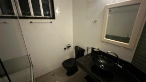 ein Badezimmer mit schwarzem Waschbecken und Spiegel in der Unterkunft Hotel Arsenal in São Gonçalo
