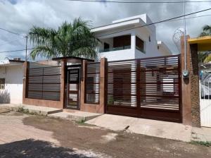 a house with a wooden gate and a fence at Casa Chonita in Tecuala