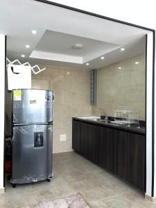 a kitchen with a stainless steel refrigerator and a counter at Las Palmas Paraíso Ricaurte in Ricaurte