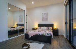 a bedroom with a bed and a large mirror at Brand New Elegant House in Marsden Park