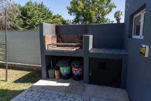 a barbecue outside a house with buckets in it at Piedras Moras cabañas in Almafuerte