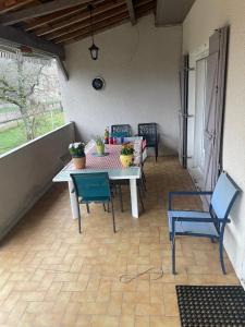 a patio with a table and chairs on a porch at Voyage in Ouroux-sur-Saône