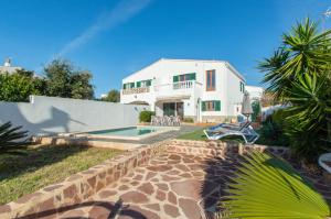 a large white house with a swimming pool in front of it at Villa Can Canaleta by Sonne Villas in Cala Galdana