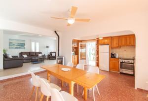 a kitchen and living room with a wooden table and chairs at Villa Can Canaleta by Sonne Villas in Cala Galdana