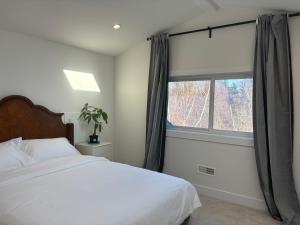 a bedroom with a white bed and a window at Comfortable Private Room in a Shared Home in Richmond