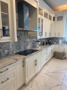 a kitchen with white cabinets and a sink at Comfortable Private Room in a Shared Home in Richmond +2 photos
