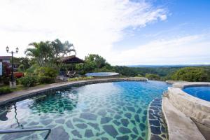 a large swimming pool with blue water at Hacienda Los Molinos Boutique Hotel & Villas in Boquete