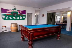 a room with a pool table and a sign on the wall at Commercial Hotel in Birchip +3 photos