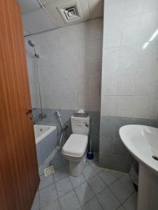 a bathroom with a toilet and a sink at Ajman Downtown Central AISOOGA in Ajman 