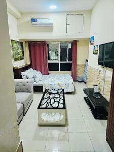 a living room with a bed and a couch at Ajman Downtown Central AISOOGA in Ajman 