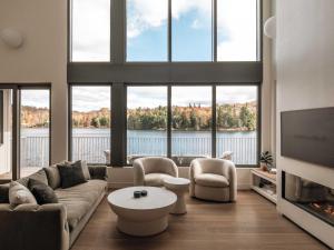 a living room with a couch and chairs and a tv at Wild Pond Villa in Mansonville